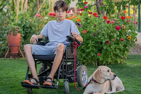 child in wheelchair with his dog