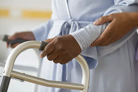 woman using a walker with assistance